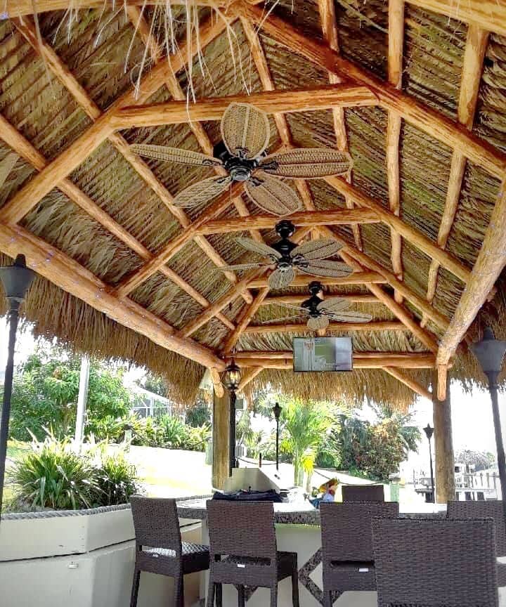 Dockside tiki built over a large dining set on a dock.