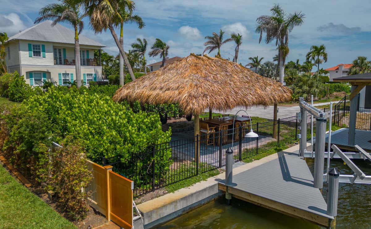 Tiki with a seating area built next to a sea wall, overlooking a canal.