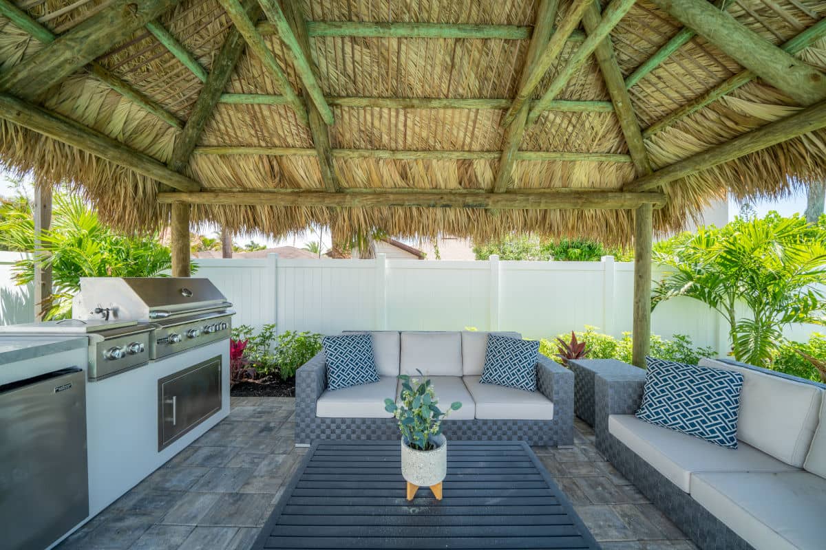Outdoor kitchen and seating area built in a back yard.